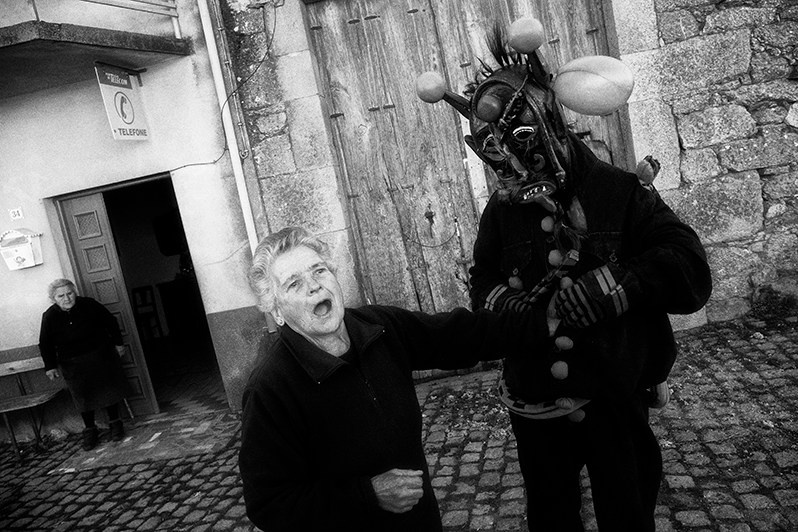 An inhabitant of the village offers oranges to the “Chocalheiro” and places them inside his clothes, the “mangão”, Mogadouro municipality, Bragança district, Trás-os-Montes region, Portugal. 2019
