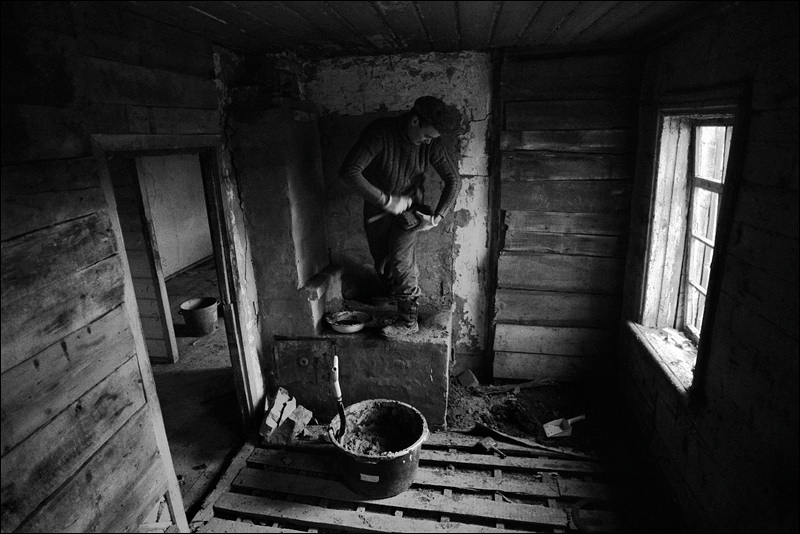 "Repairing the furnace in an abandoned house", farm of Senshin, village of Oblivskaya district, Rostov-on-Don region, Russia, January 2011
