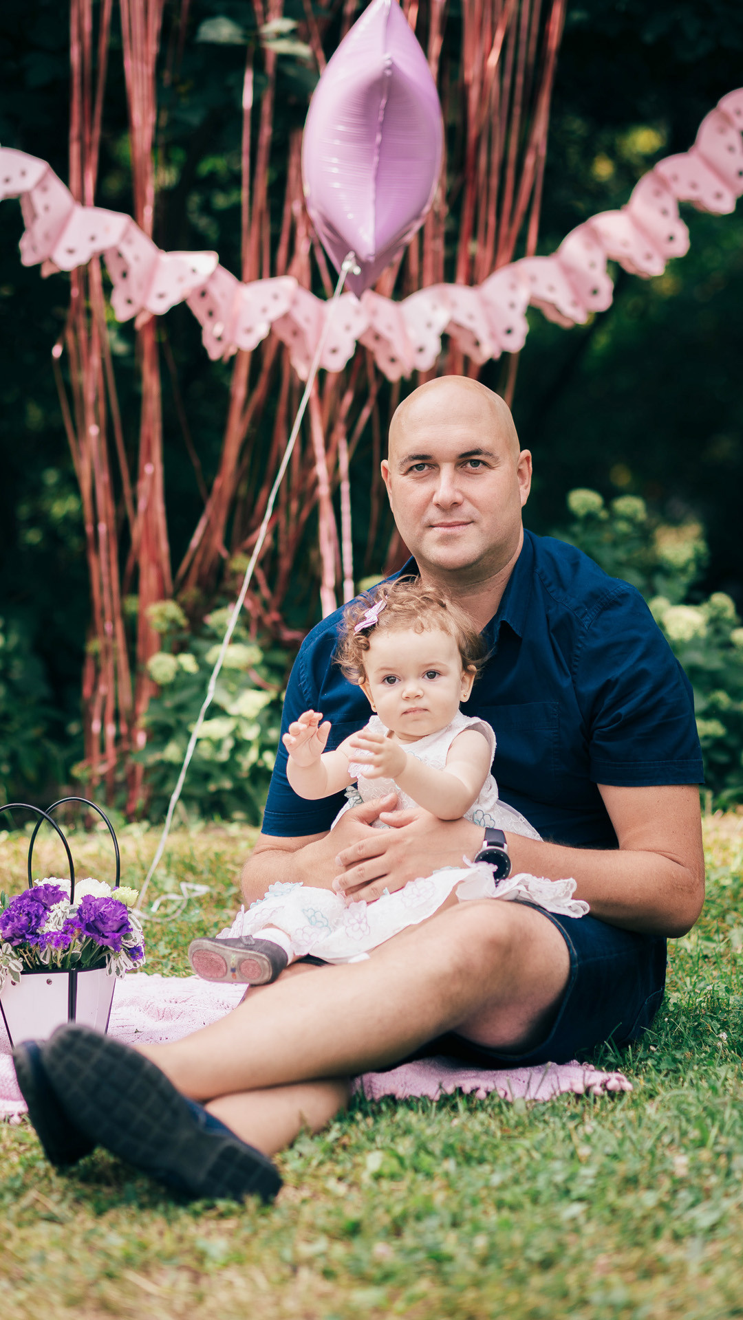 Сімейна фотосесія в парку Дніпра — дівчинка грає з батьками.