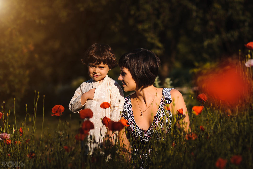 Семейная съемка в Днепре — родители держат детей за руки на траве.