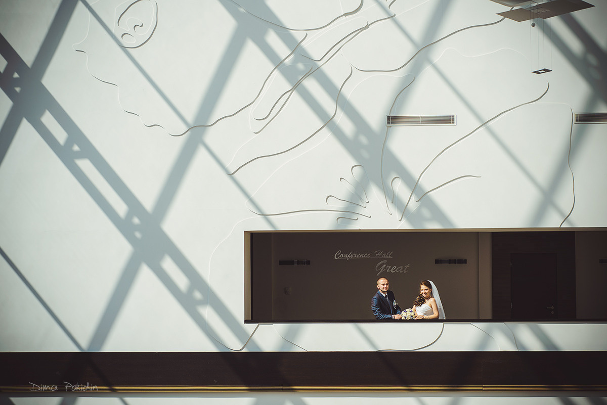 Весільна фотосесія на даху в Дніпрі — пара на фоні міських пейзажів, щасливо разом, підносячи келихи за своє кохання.