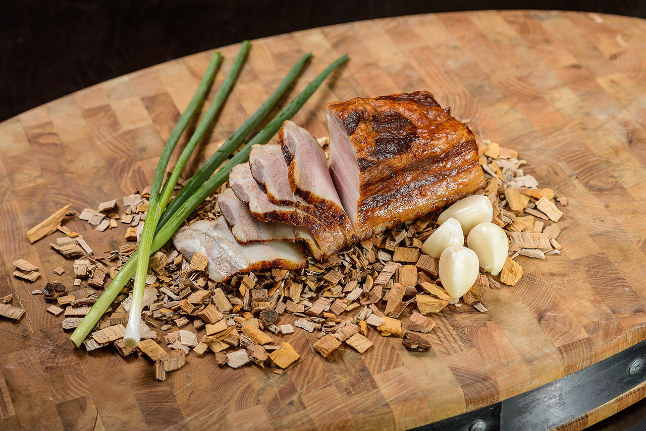 Фотограф у Дніпрі — нарізане сало з часником на дерев’яній дошці.