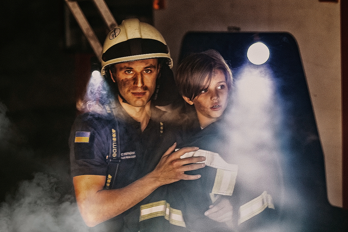 Спасатель пожарный с ребенком на руках 