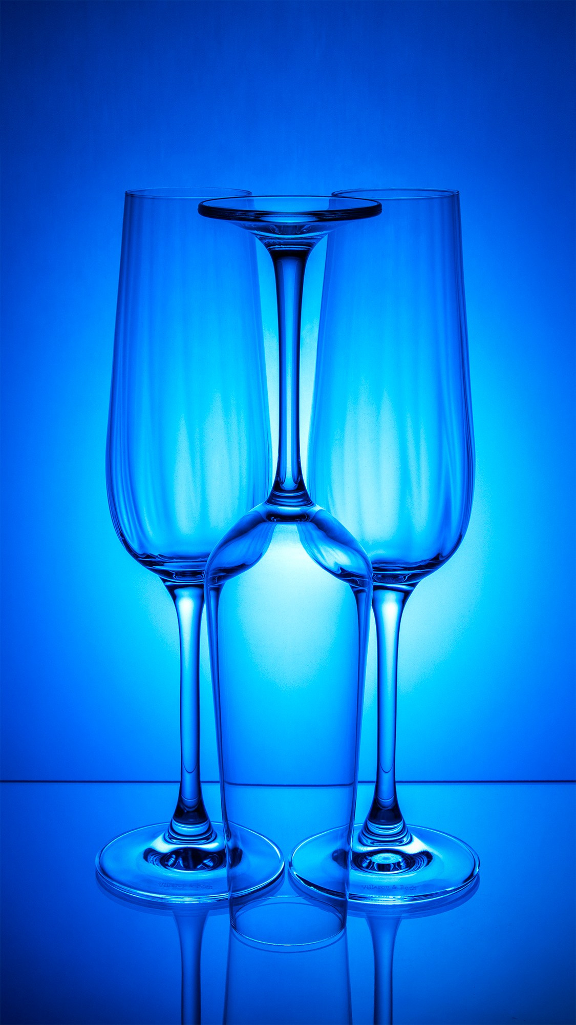 Photographer Roman Djuzev - A photograph of three glass champagne glasses standing next to each other on a colored background.