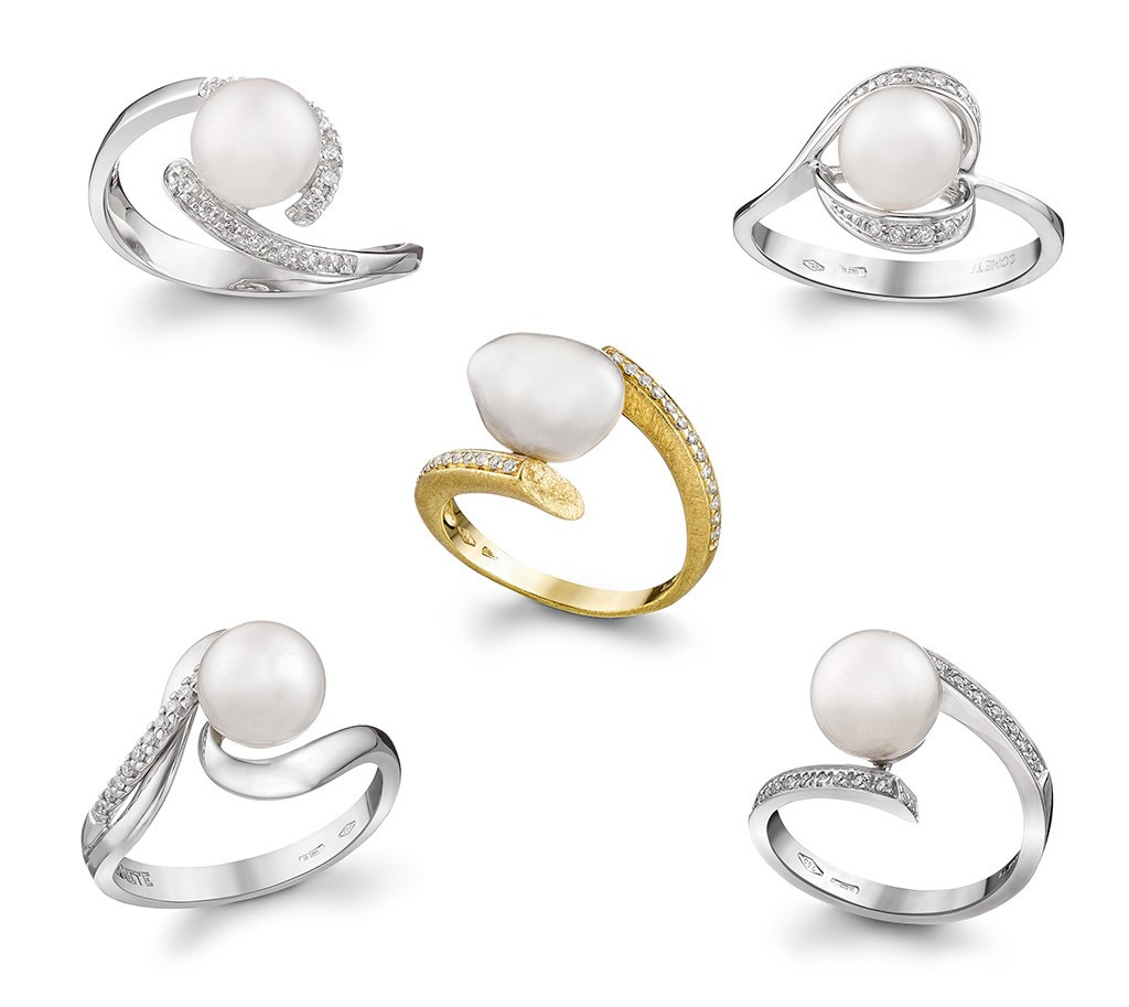 Pet zlatnih dijamantskih prstena na beloj pozadini.