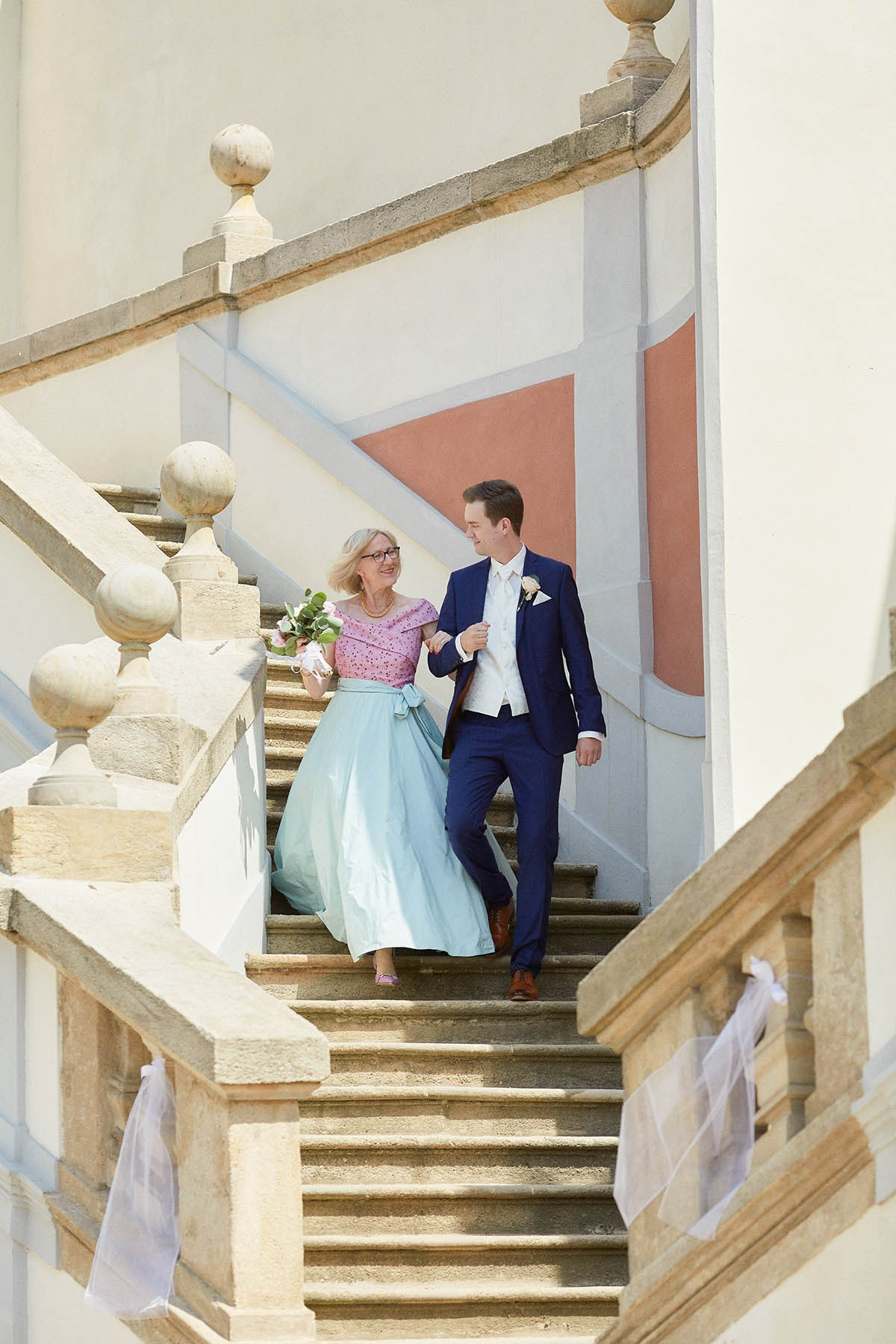 Matthias escorts his mother down into the garden below Prague Castle, heralding the start of the wedding.