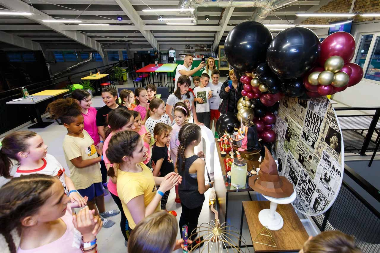 Igraonica sa puno dece u iščekivanju torte i duvanja svećica.