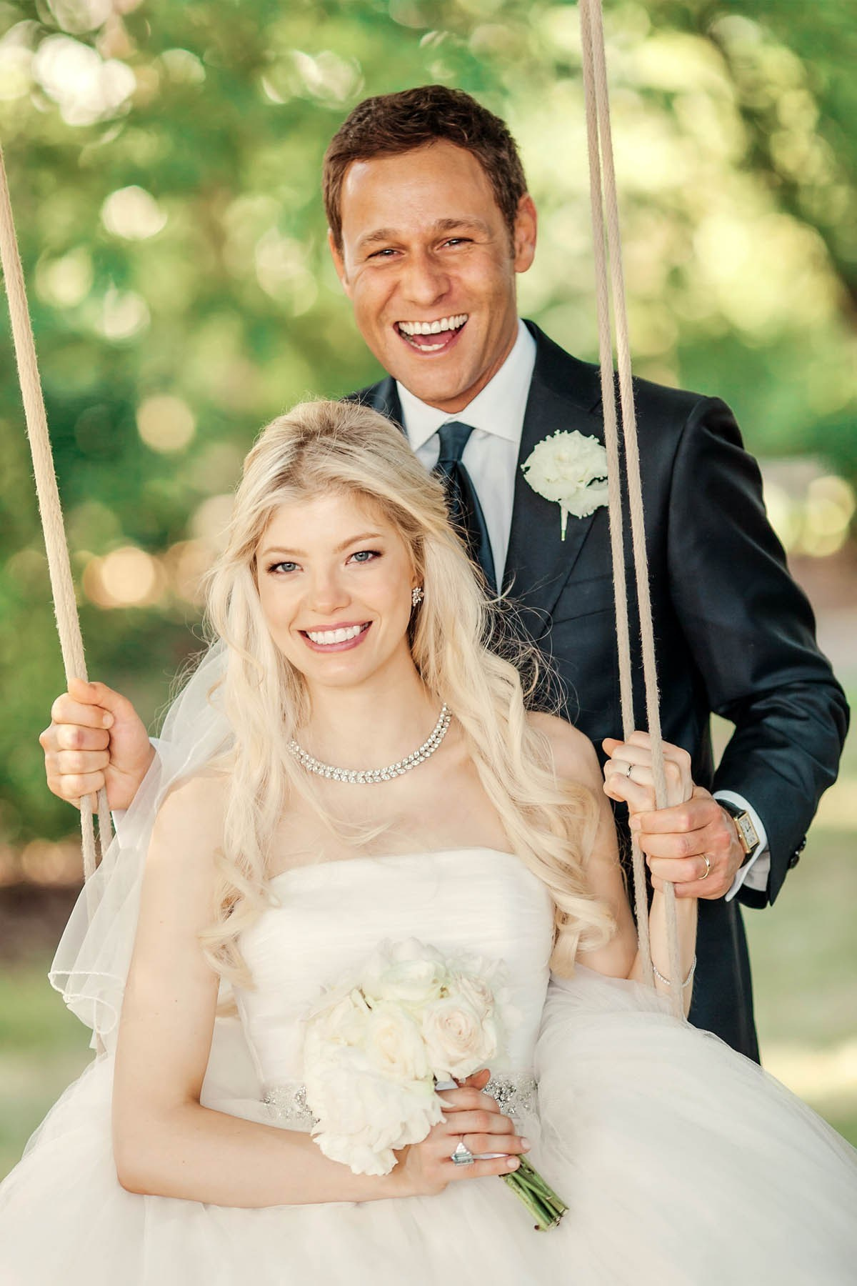 Bride on swing with groom at Prague Castle garden wedding