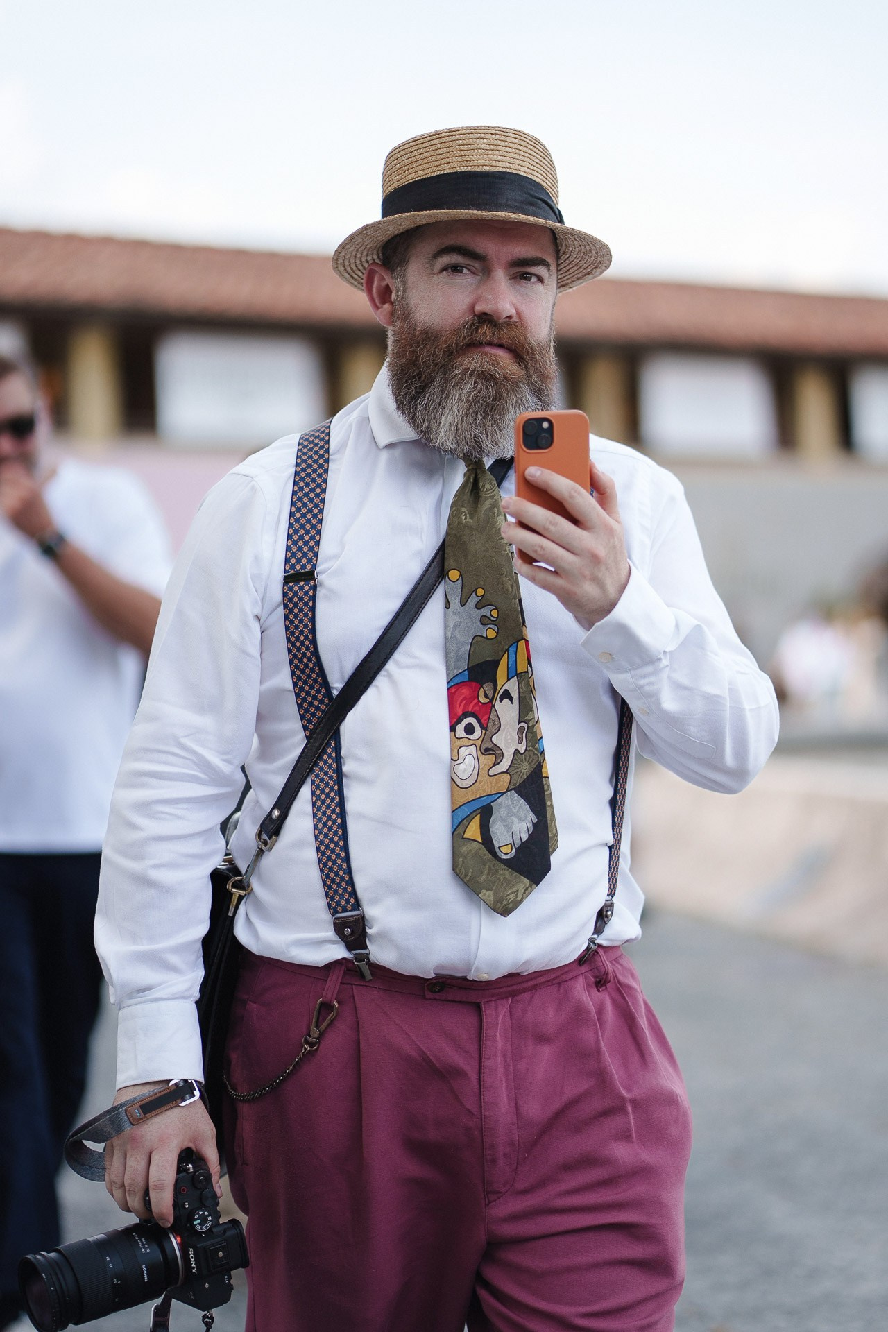 Pitti Uomo 110 street style portrait, bearded guest in straw hat with camera and patterned tie