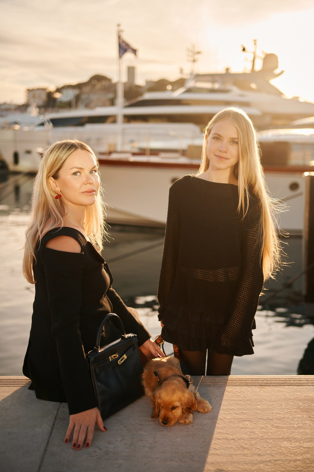 Family photo of mom, daughter and dog near luxury yachts in Cannes France
