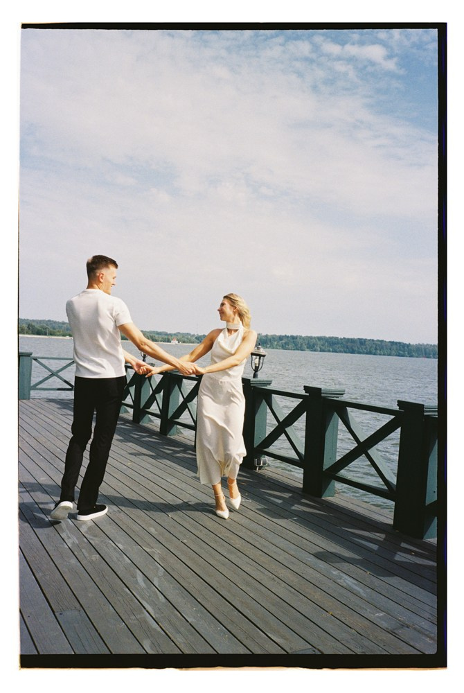 Couple walking on pier during seaside destination wedding