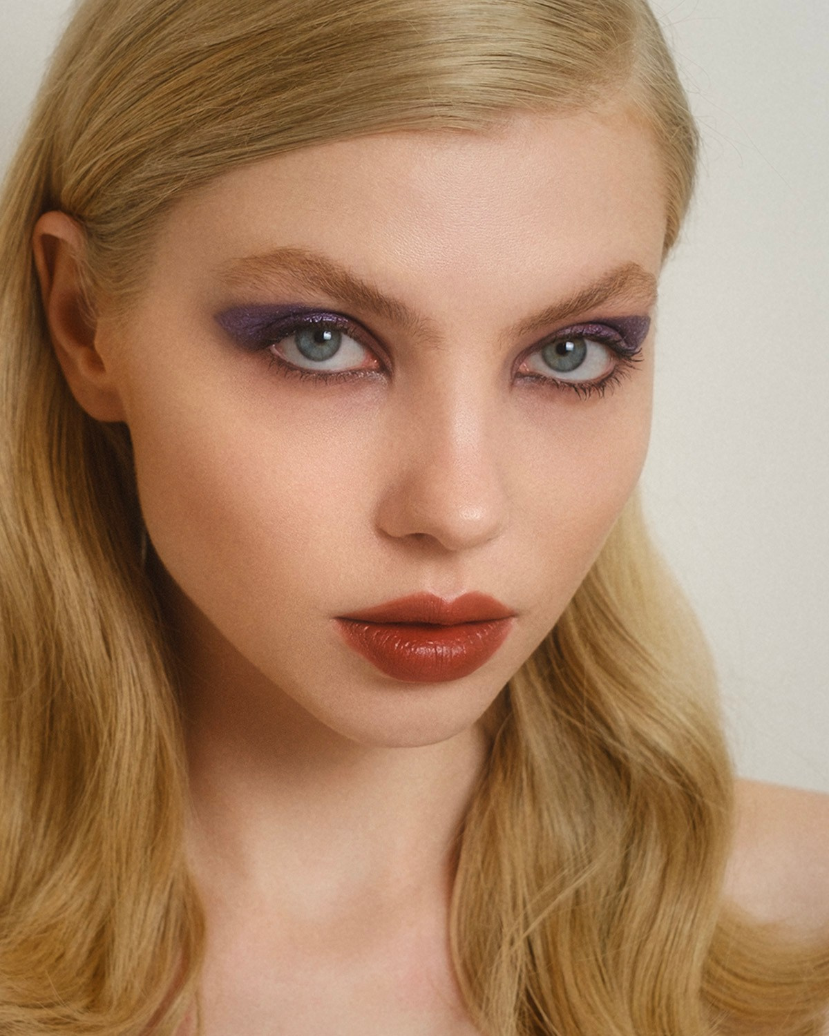 Commercial beauty photography featuring dramatic purple eyeshadow and bold lip look