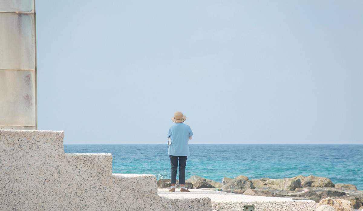 Woman standing with her back looking at the sea anna biletska