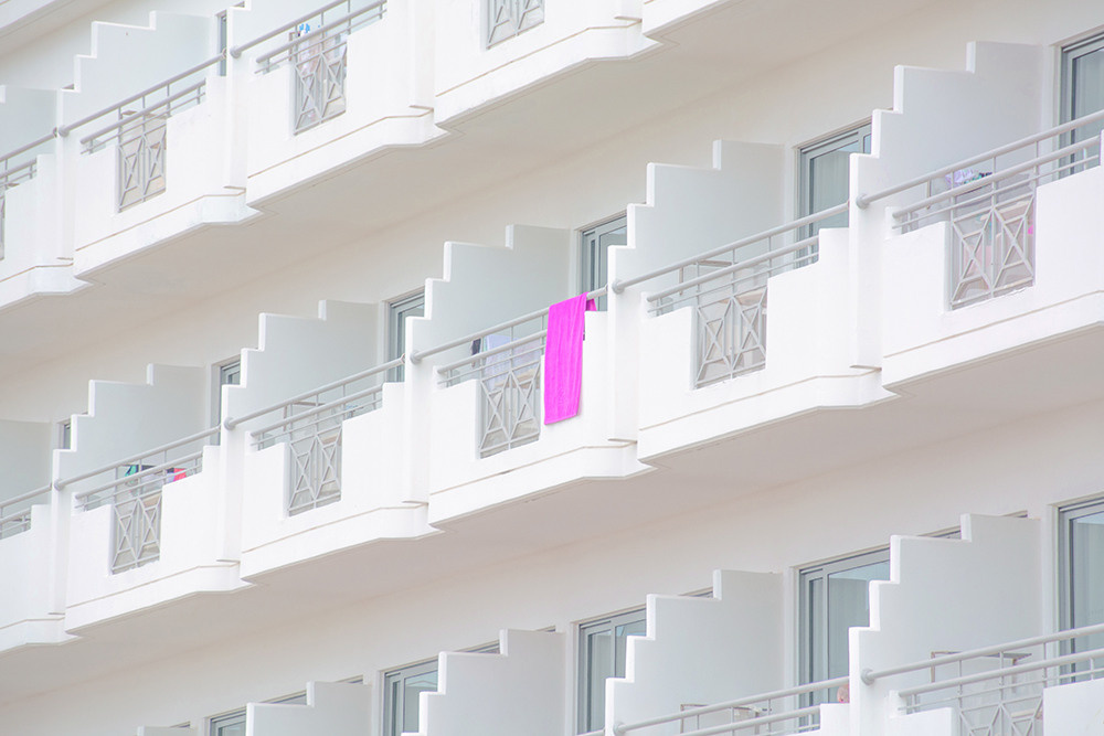 Pink towel hanging on the background of a white hotel anna biletska