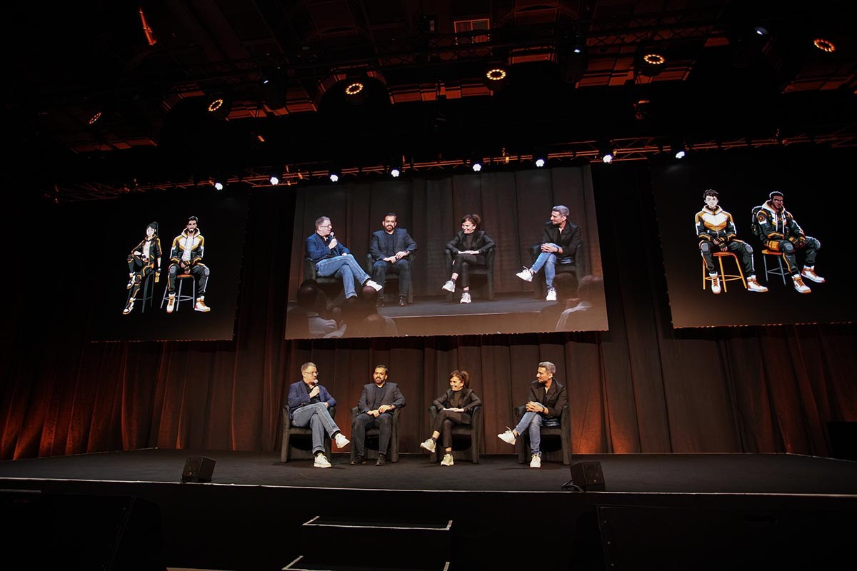 Wide-angle shot of panel discussion on stage with a large audience at the Orange Business conference, Hilton Prague event.