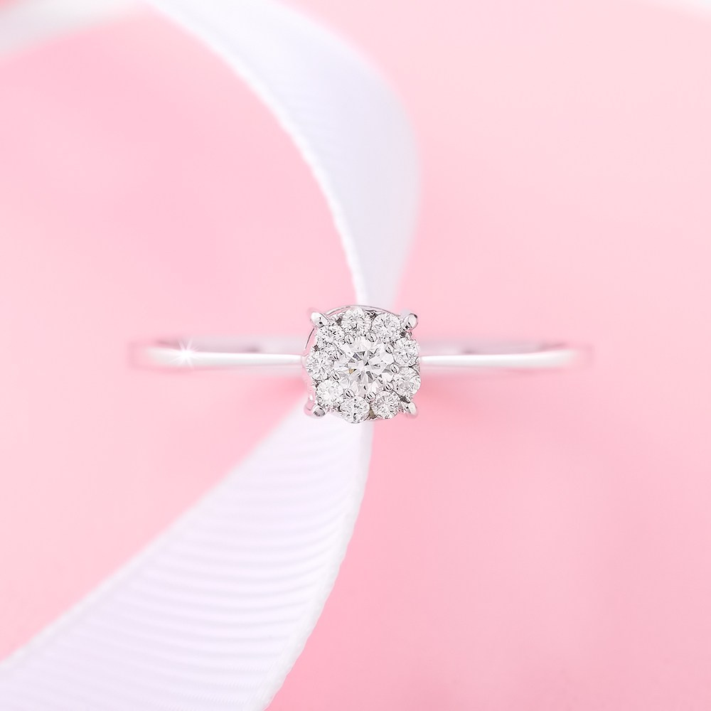 Dijamantski prsten stoji usparvno na roze pozadini.