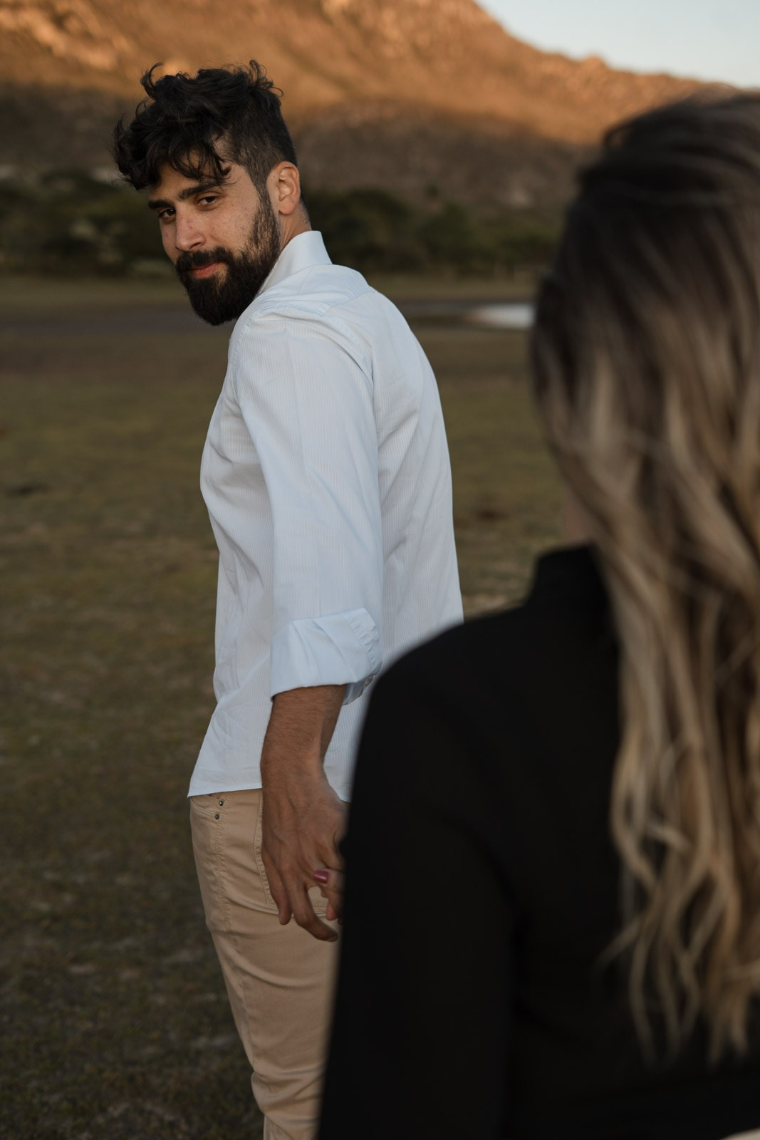 Pré-wedding Sabrina e Vinícius em Lapinha da Serra MG, campo aberto com montanhas e céu livre, fotografia documental que registra conexão real do casal.