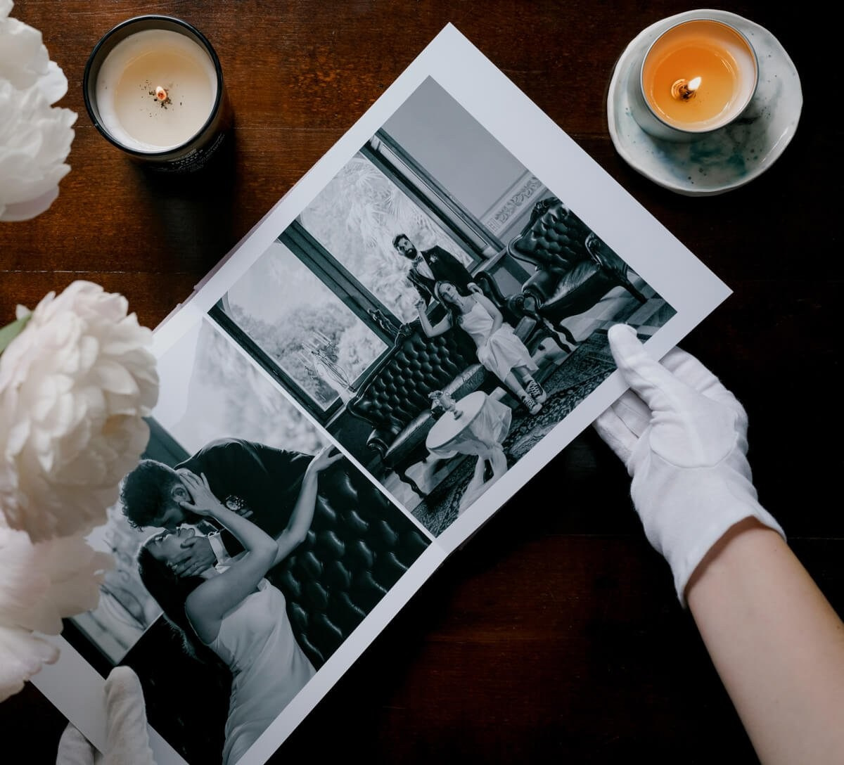 Fine art wedding print held in gloved hands beside candles