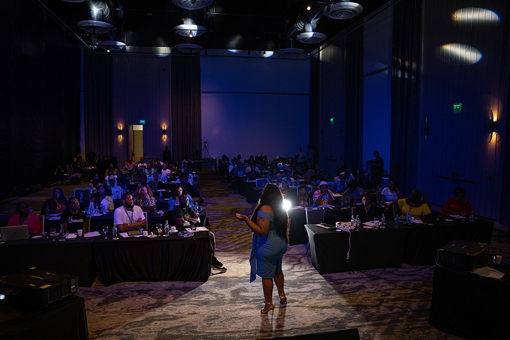 Speaker giving motivational talk to attentive corporate group.