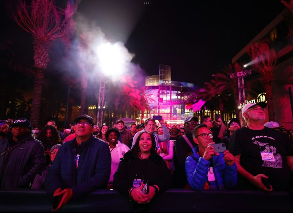Audience watching an outdoor corporate event in Dubai under magenta lighting