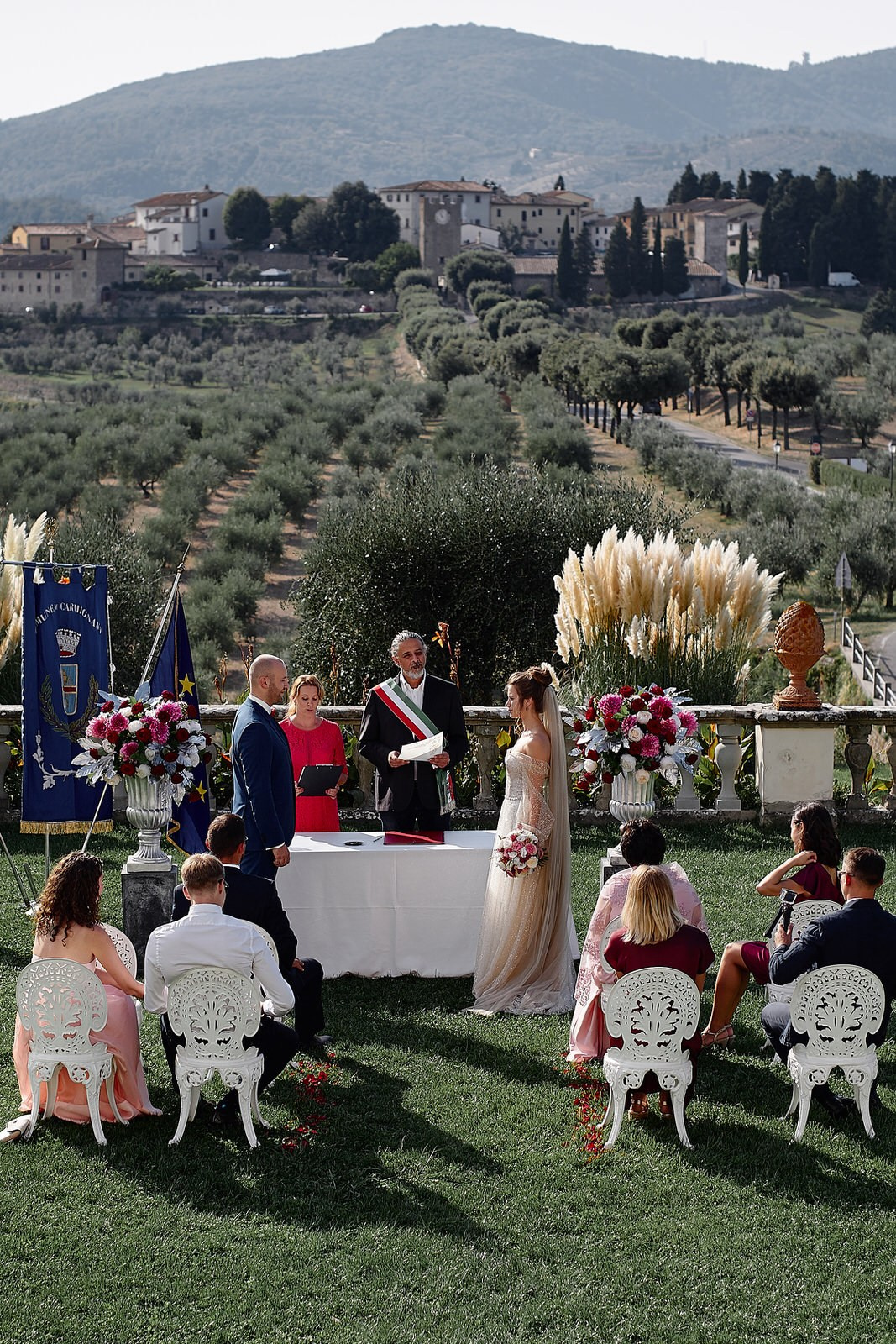 Wedding ceremony at Villa Medicea La Ferdinanda, Artimino — couple exchanging vows surrounded by panoramic Tuscan hills and cypress trees