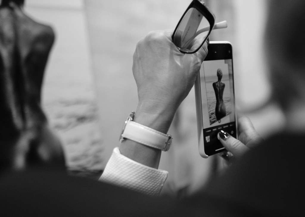 Guest photographing a sculpture at a cultural event in Paris