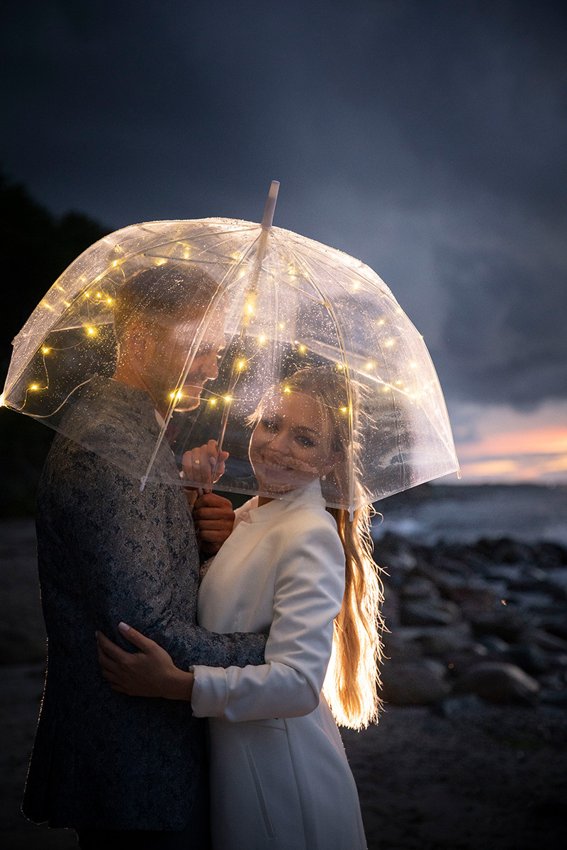 Brautpaar im Dunkeln unter dem durchsichtigen Schirm mit Lichtern,  kreatives bild