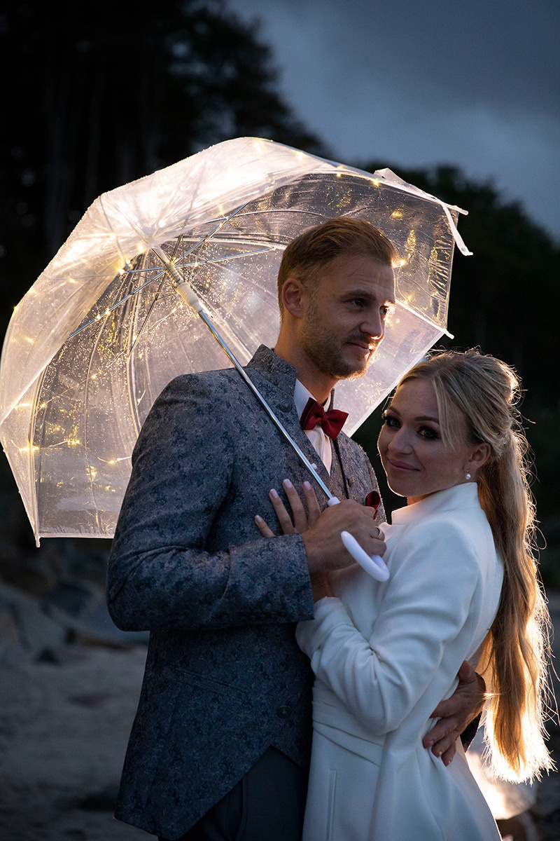 Brautpaar im Dunkeln unter dem durchsichtigen Schirm mit Lichtern,  kreatives bild