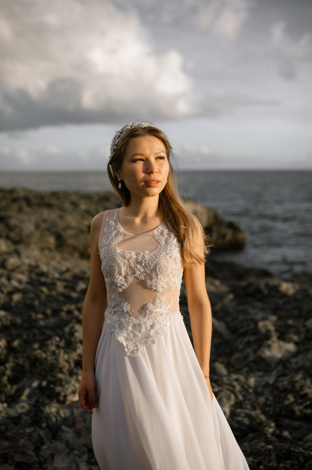 Невеста в свадебном платье на фоне лесного массива и моря.