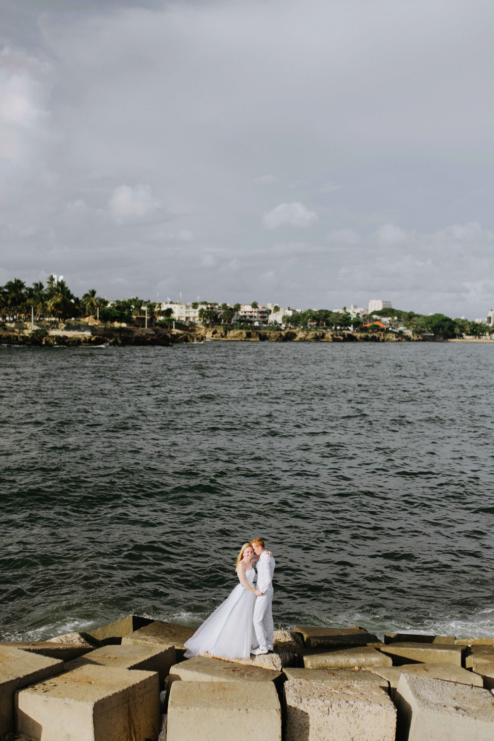 Жених с невестой на фоне морского залива.