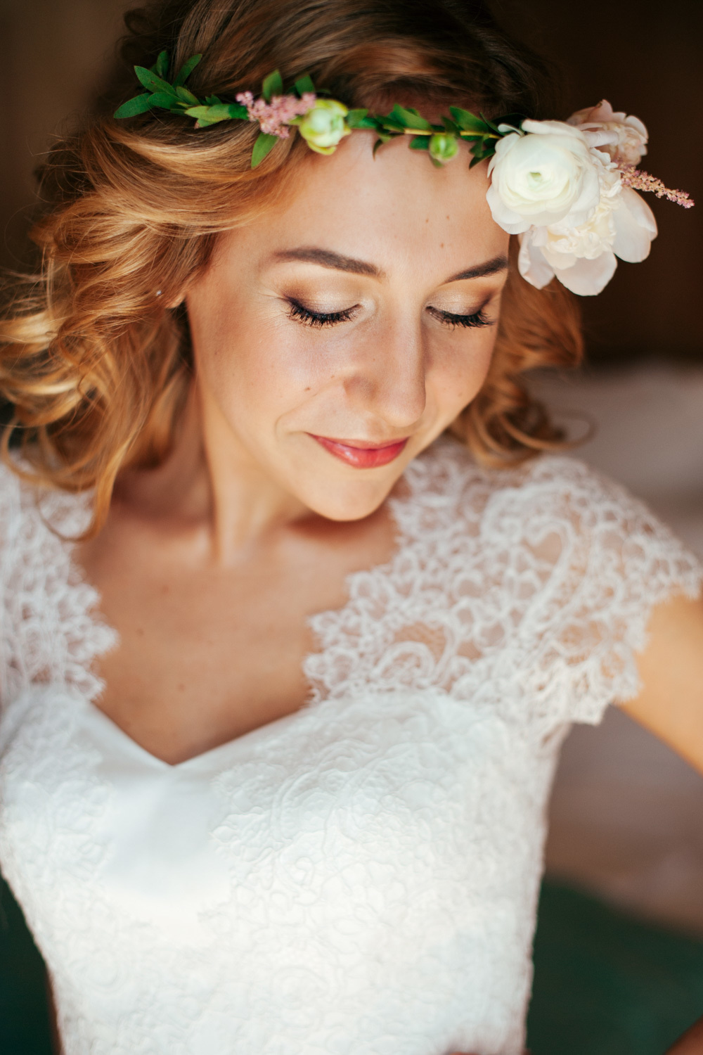 The bride's face in a white dress and a wreath.