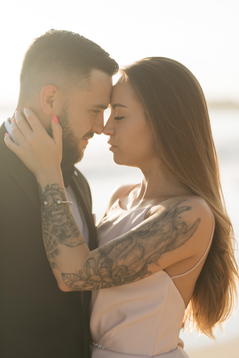 The bride and groom are leaning against each other.