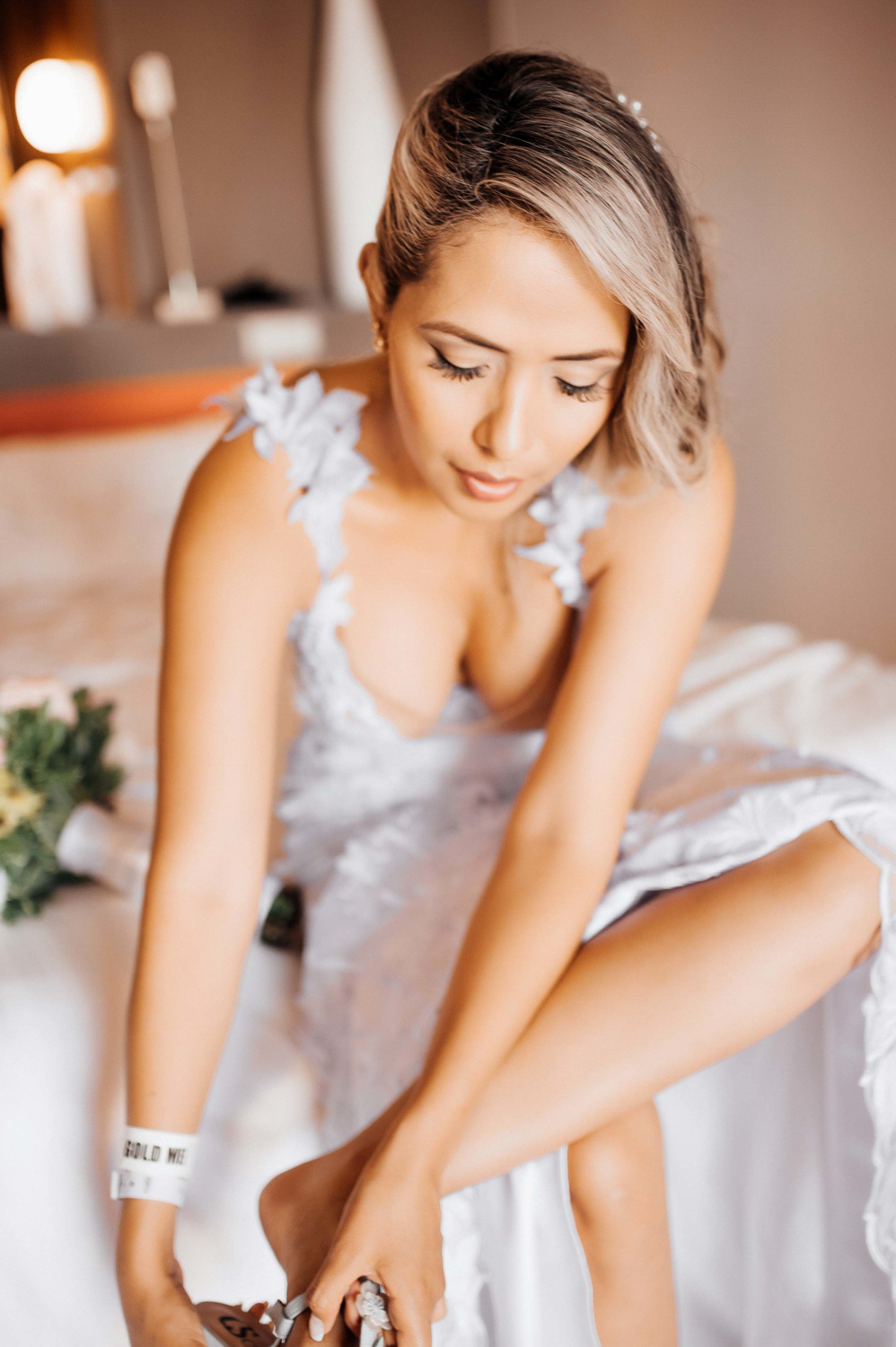The bride puts on her wedding shoes.