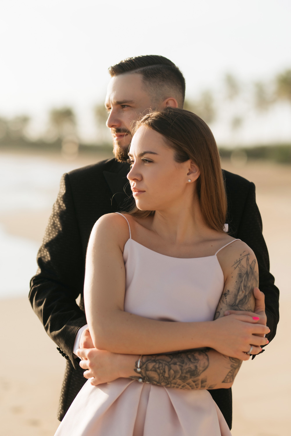 The groom hugged the bride. Their faces are directed towards the dawn.