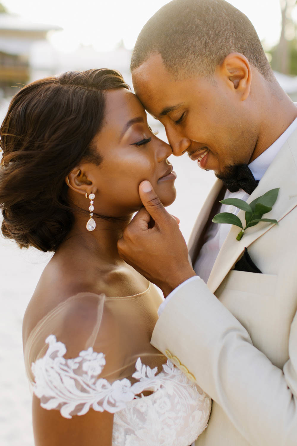 The bride and groom are standing with their arms around each other.