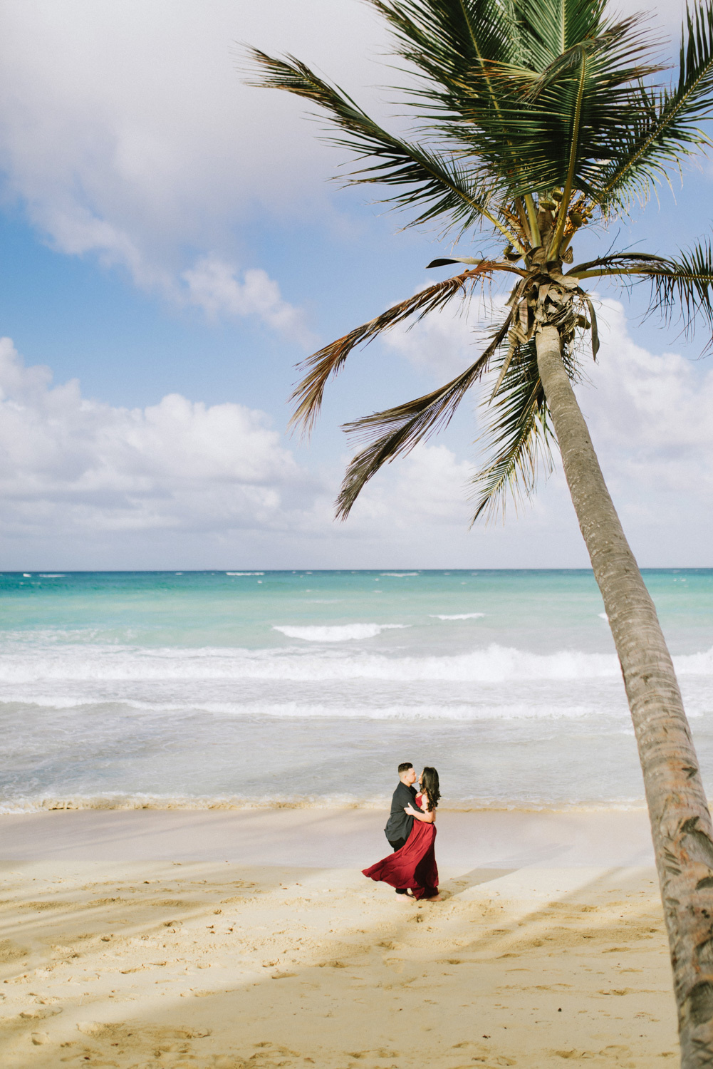 Жених и невеста на фоне пальмы у моря.