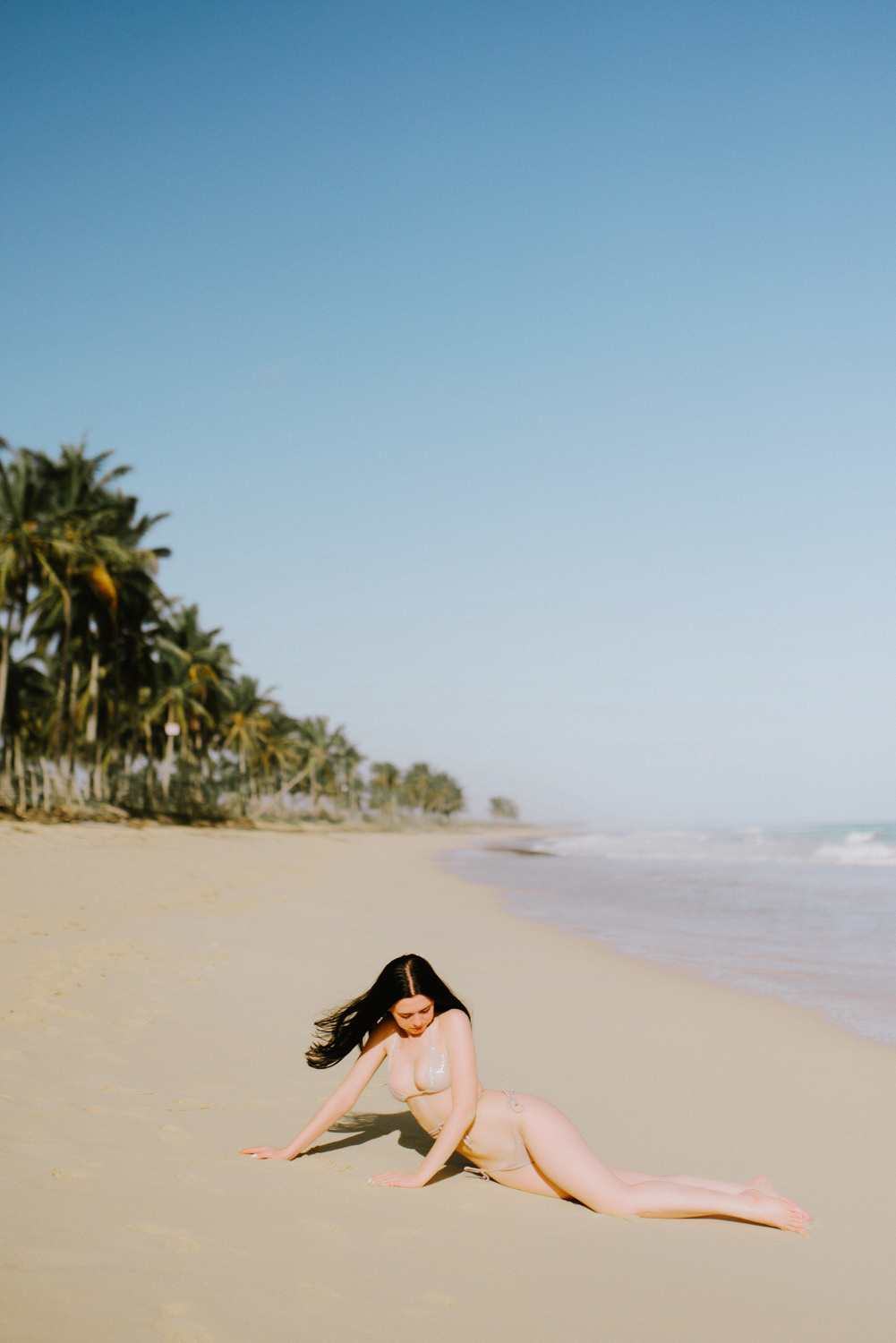 Bride in a swimsuit on the background of the sea and the beach with palm trees.