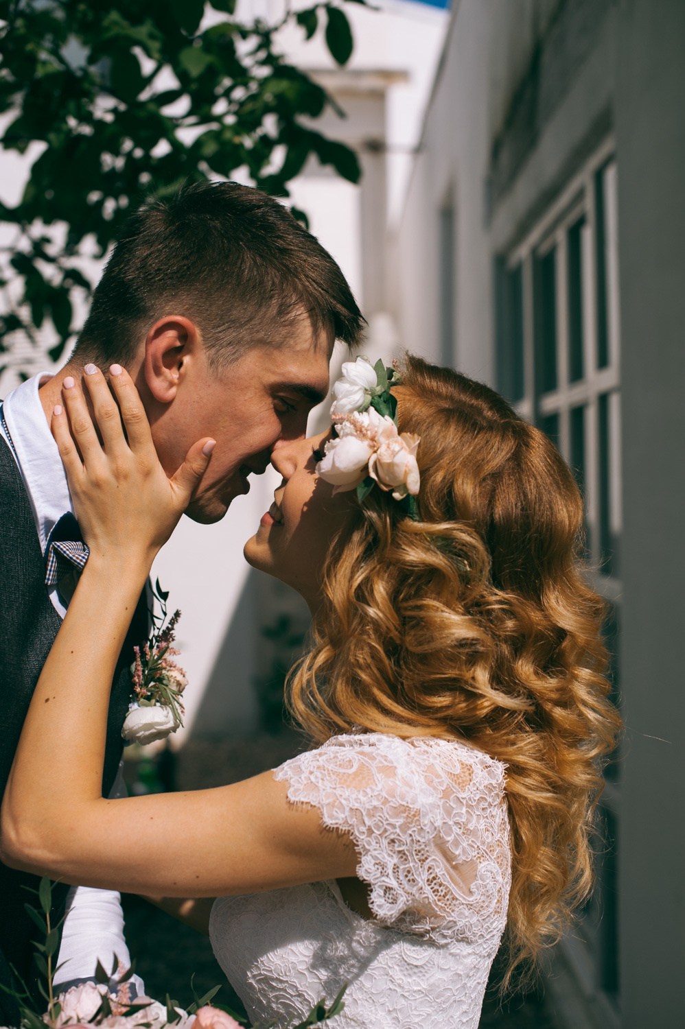 The bride embraces the groom's face against the background of the White House window.