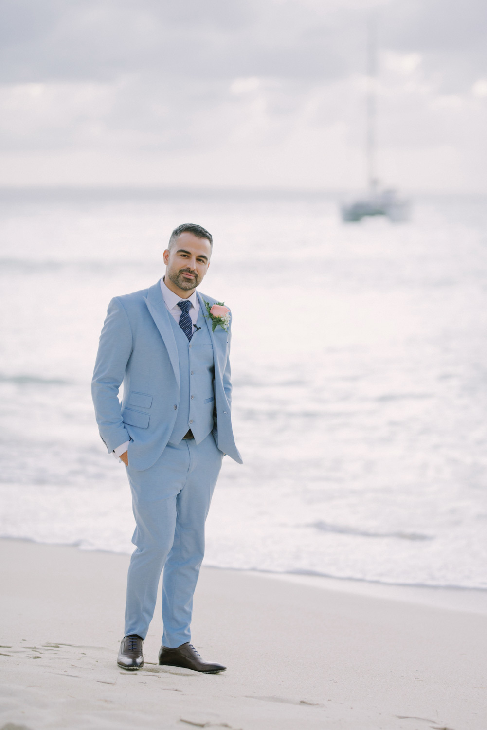 Groom on the background of the sea and a sailboat.
