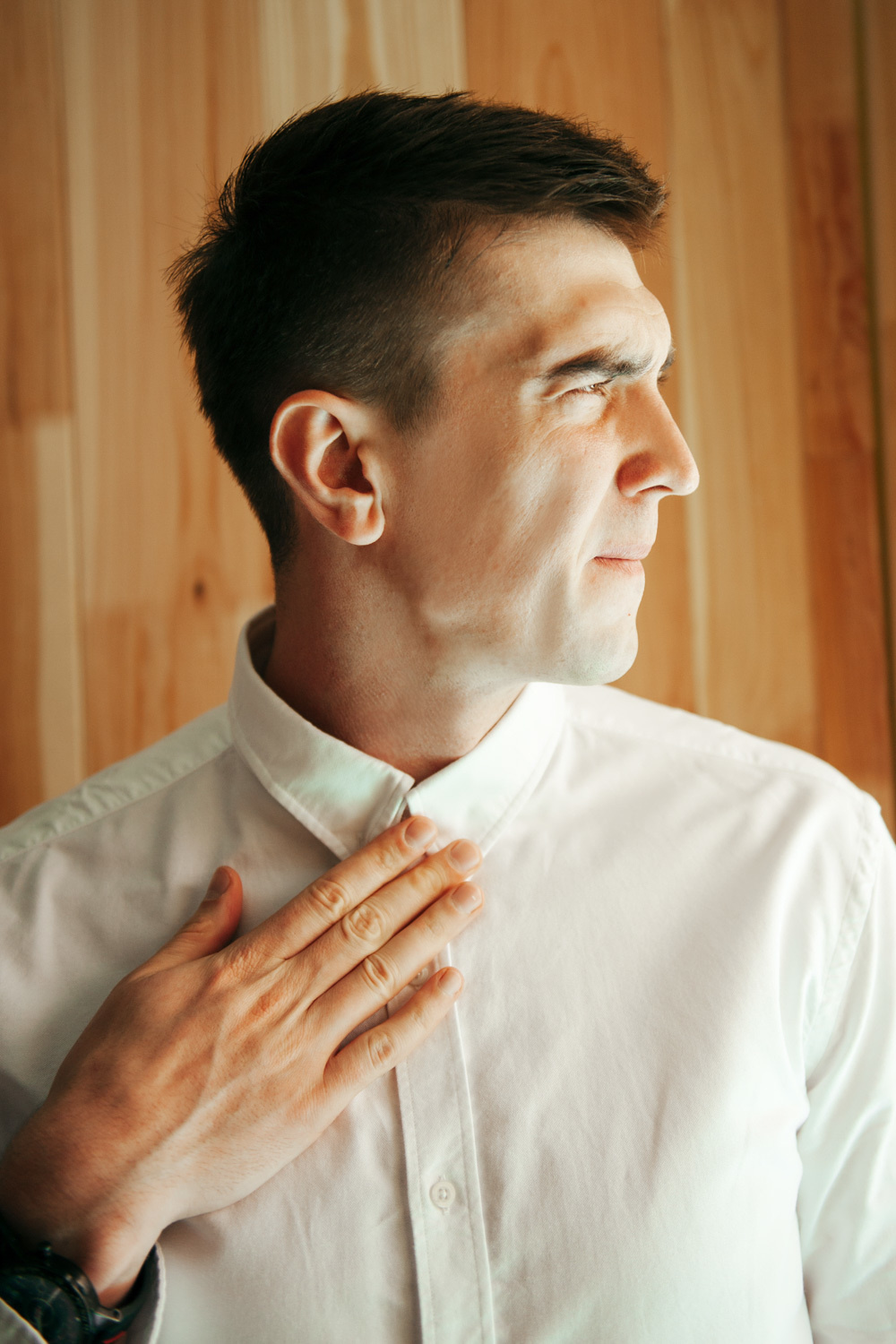 Close-up of the groom's face in a white shirt.