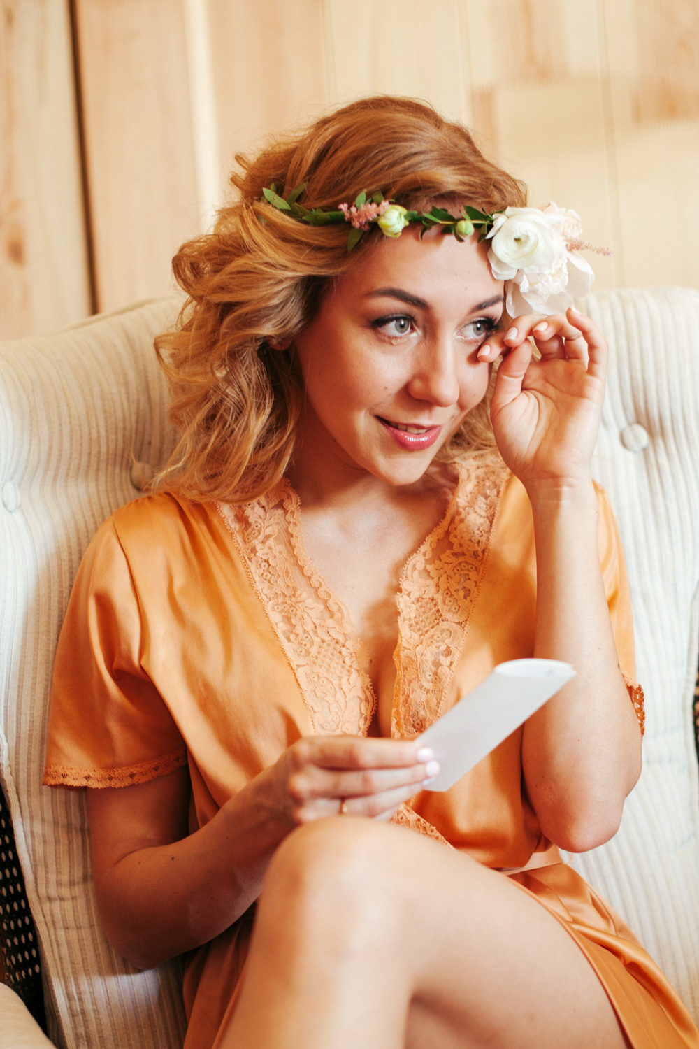 A girl wipes away a tear after reading a postcard.
