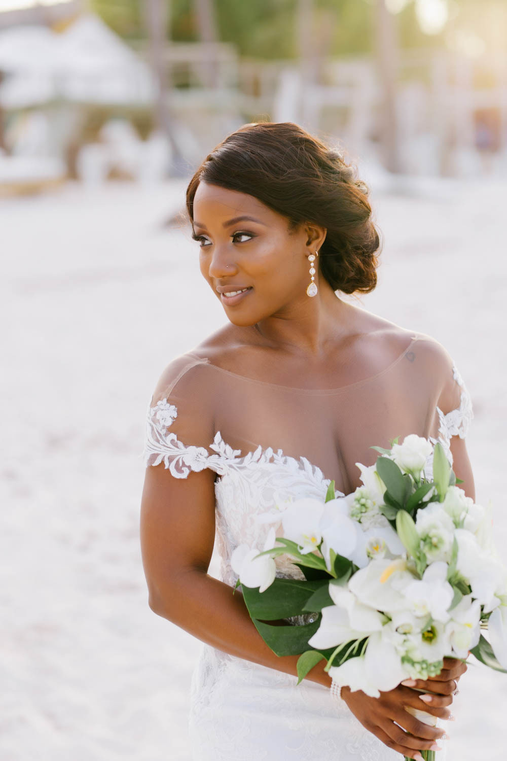 Happy bride in a wedding dress with a bouquet of white flowers.