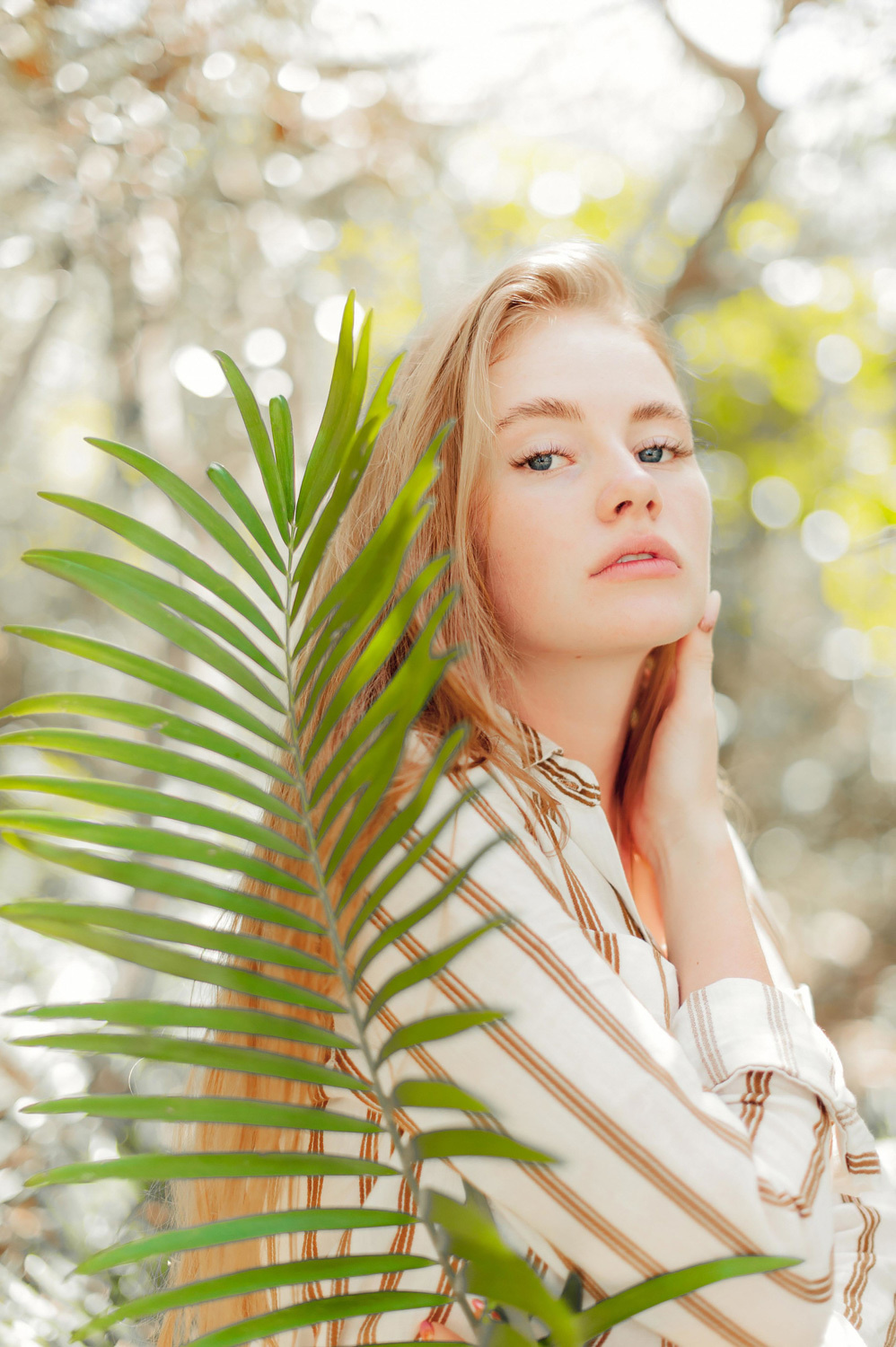 Girl's face on the background of a palm leaf.