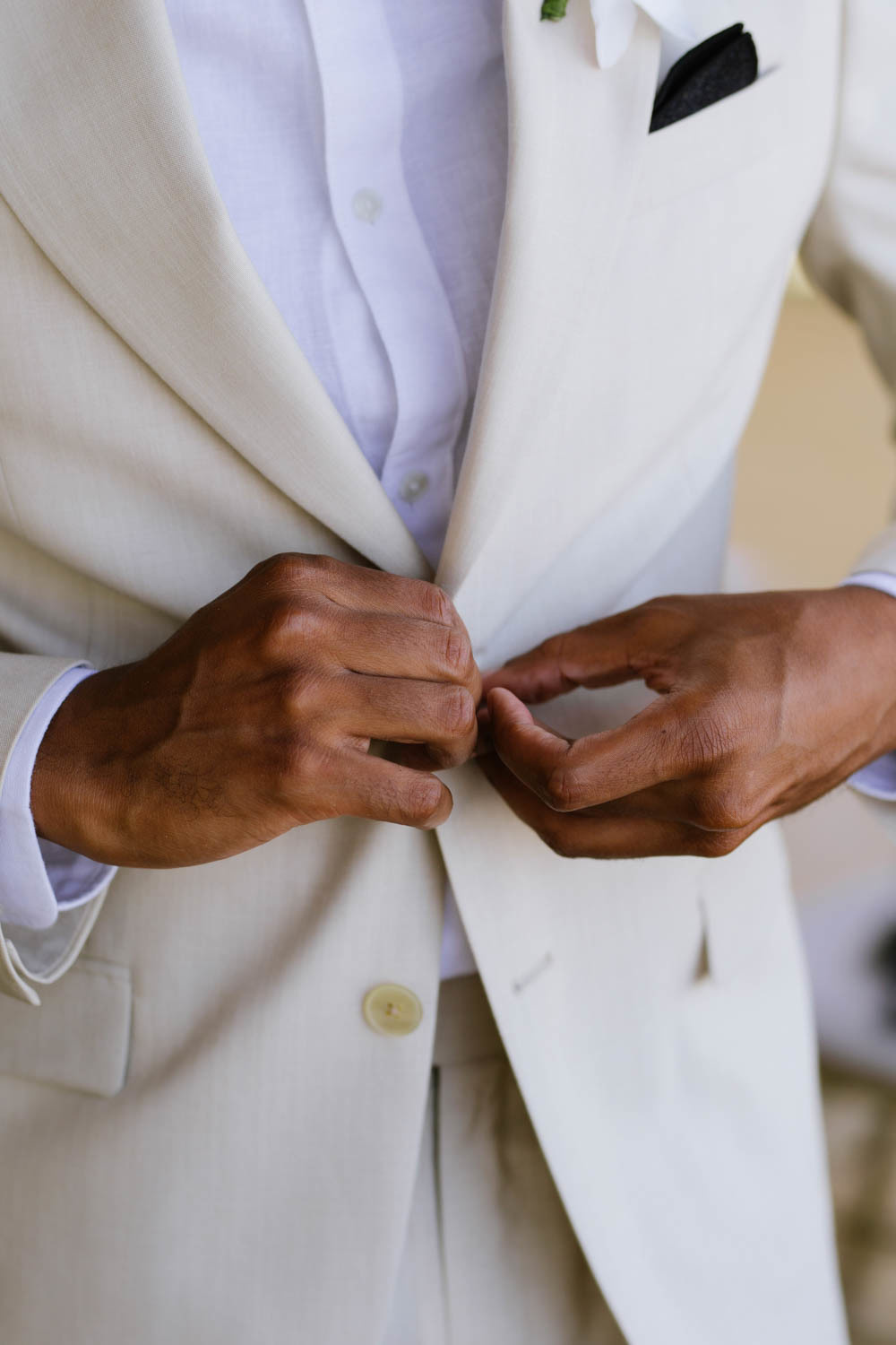The groom fastens the buttons of his jacket.