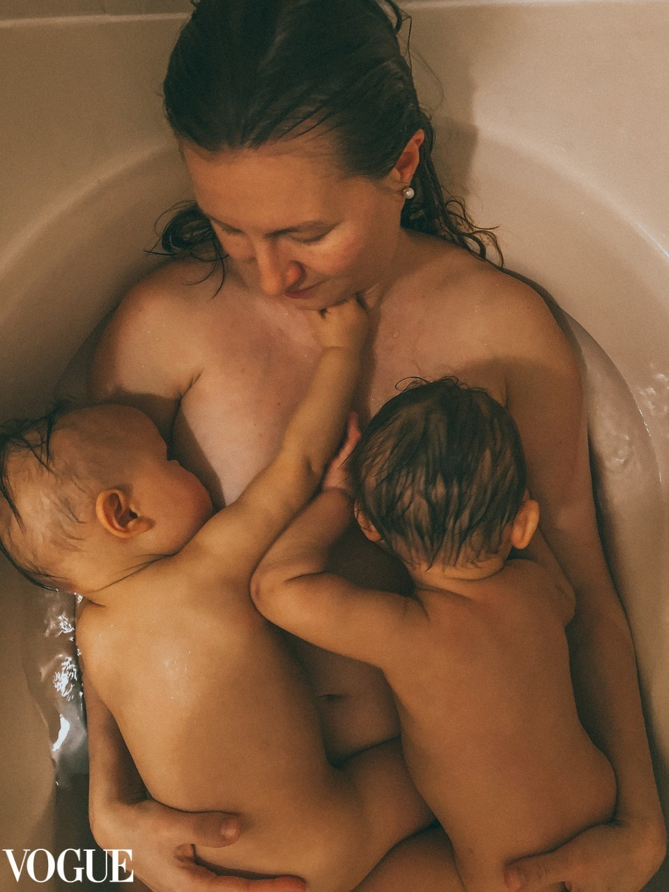 Intimate fine art portrait of a mother breastfeeding newborn twins, powerful maternity photography in Solihull.