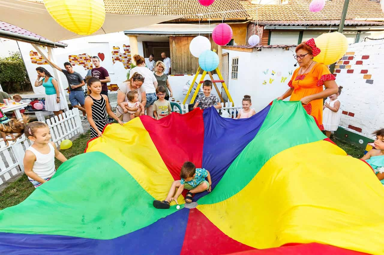 Grupne aktivnosti sa animatorima na rođendanskom slavlju. Timskie igre i zabava uz šareni padobran za decu.