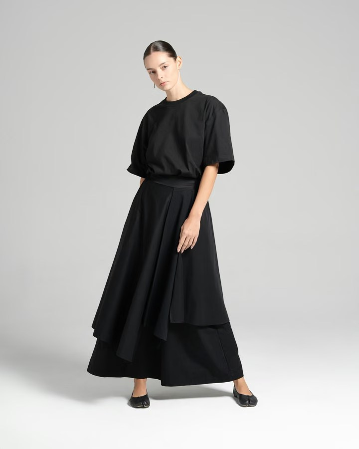 Model posing in a black outfit during a minimalist fashion photography session