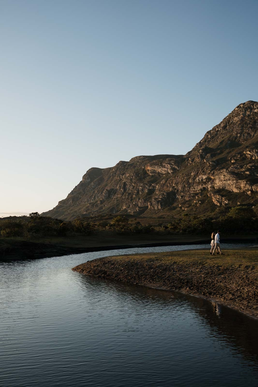 Sabrina e Vinícius em ensaio pré-wedding em Lapinha da Serra MG, fotografia documental no campo aberto, com luz natural, vento leve, paisagens amplas e emoção real em cada clique, capturado por Edu e Josi Fotografia com estilo autêntico e sensível.