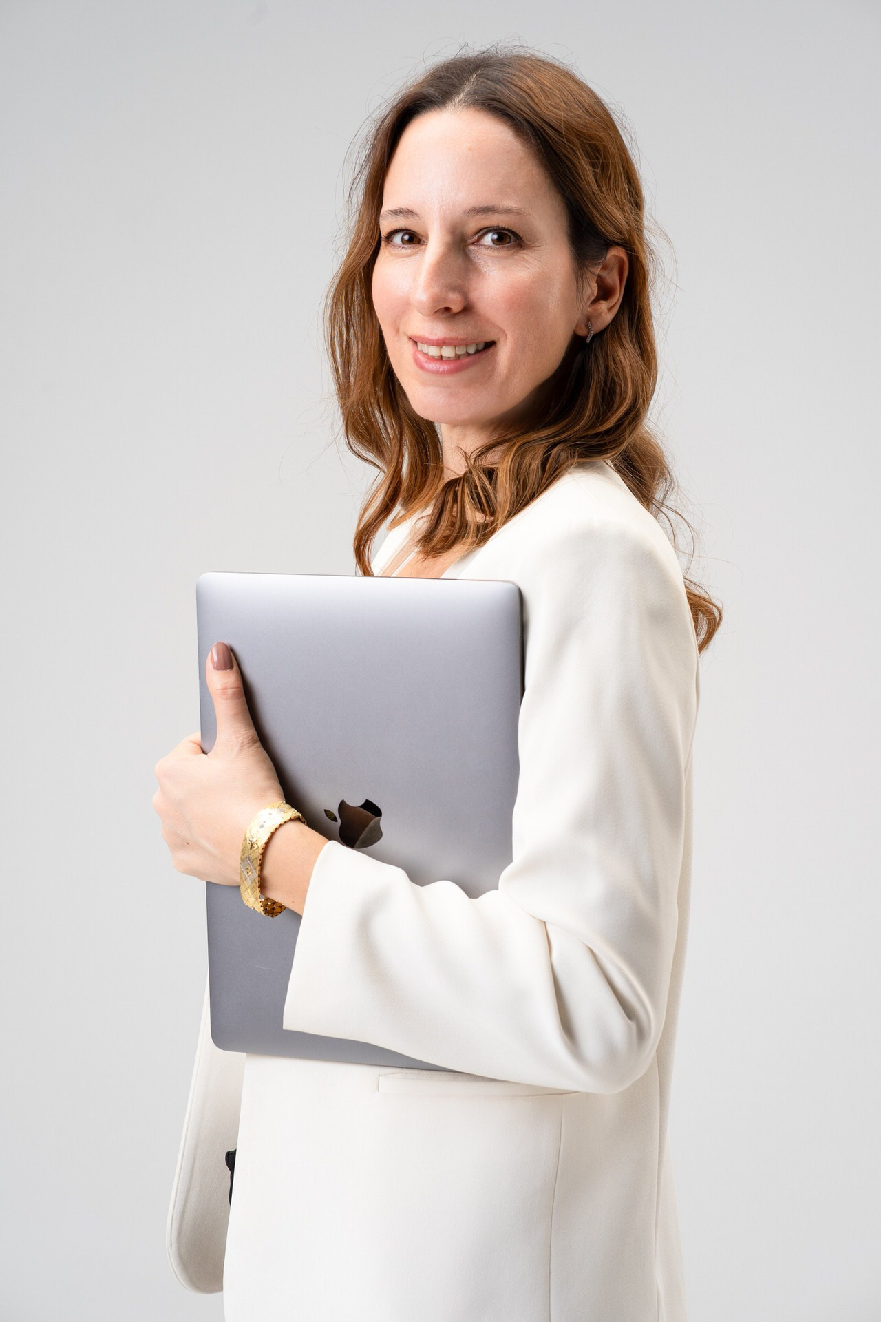 portret žene sa strane koja drži laptop i gleda pravo u kameru