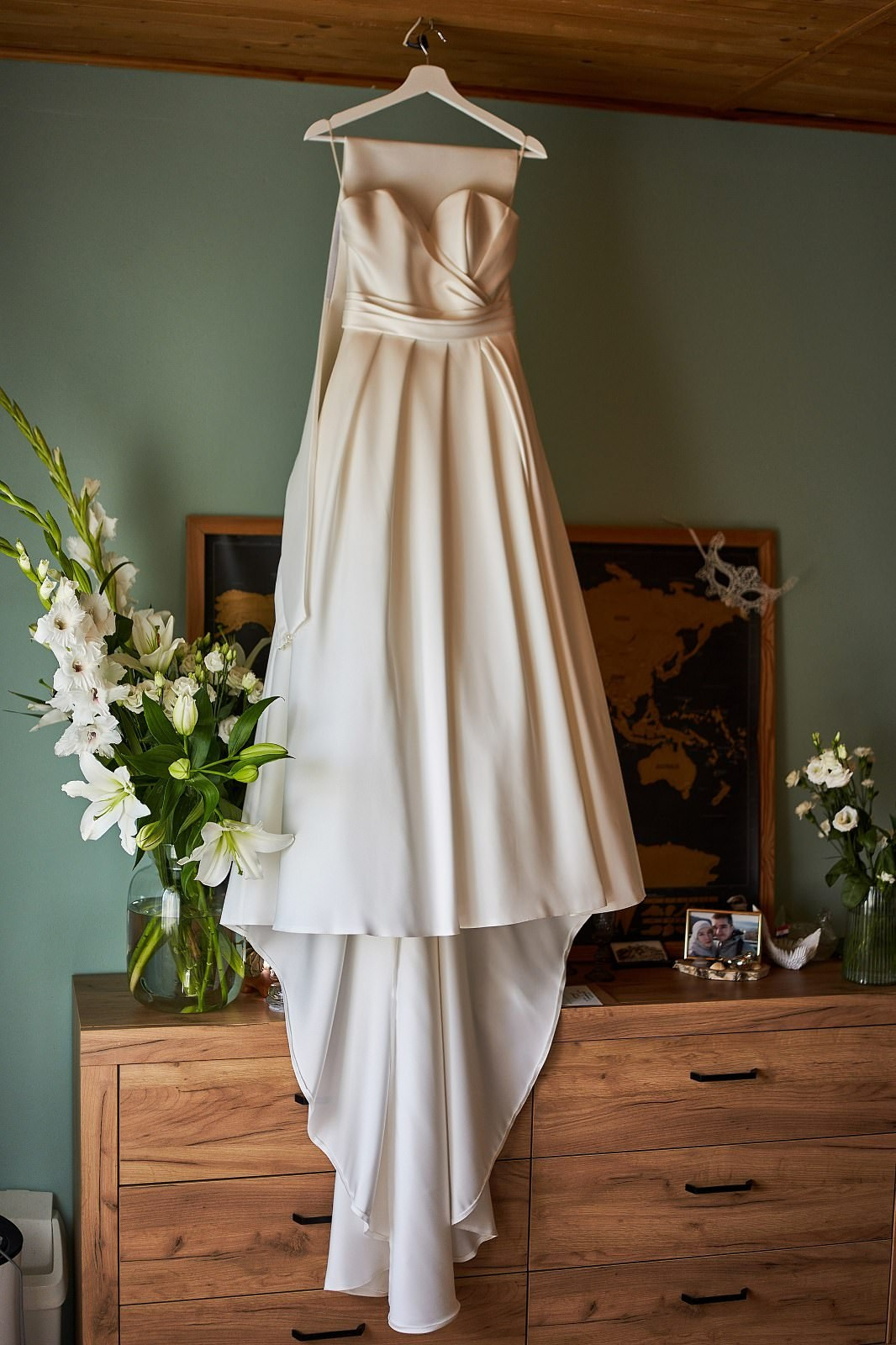 Przygotowania do ślubu: Suknia ślubna zawieszona w rustykalnym wnętrzu. Detale i klimat dnia ślubu